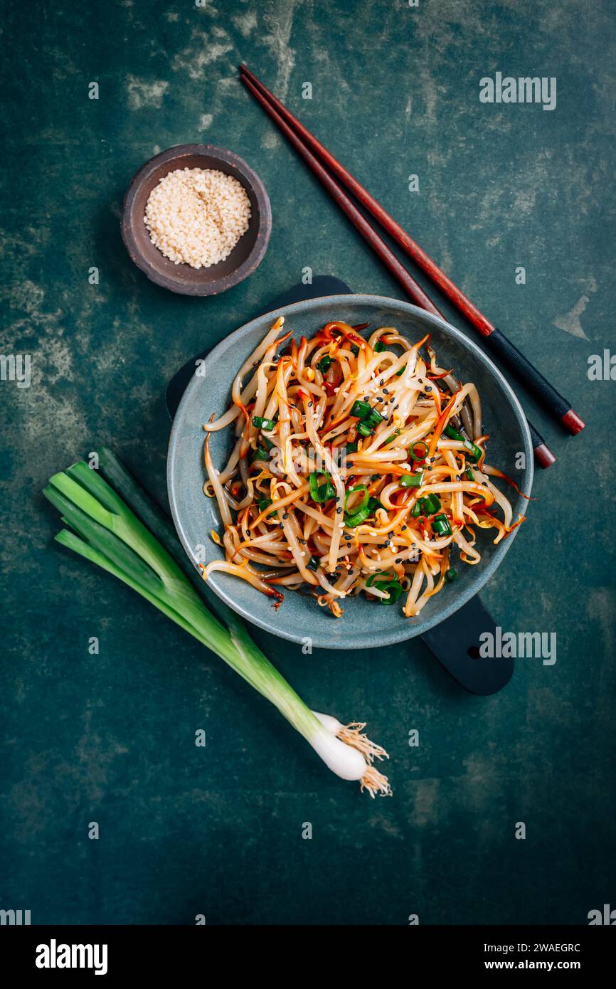 Spicy mung bean sprouts salad with garlic, sesame seeds, green onions, soy sauce, spices and red