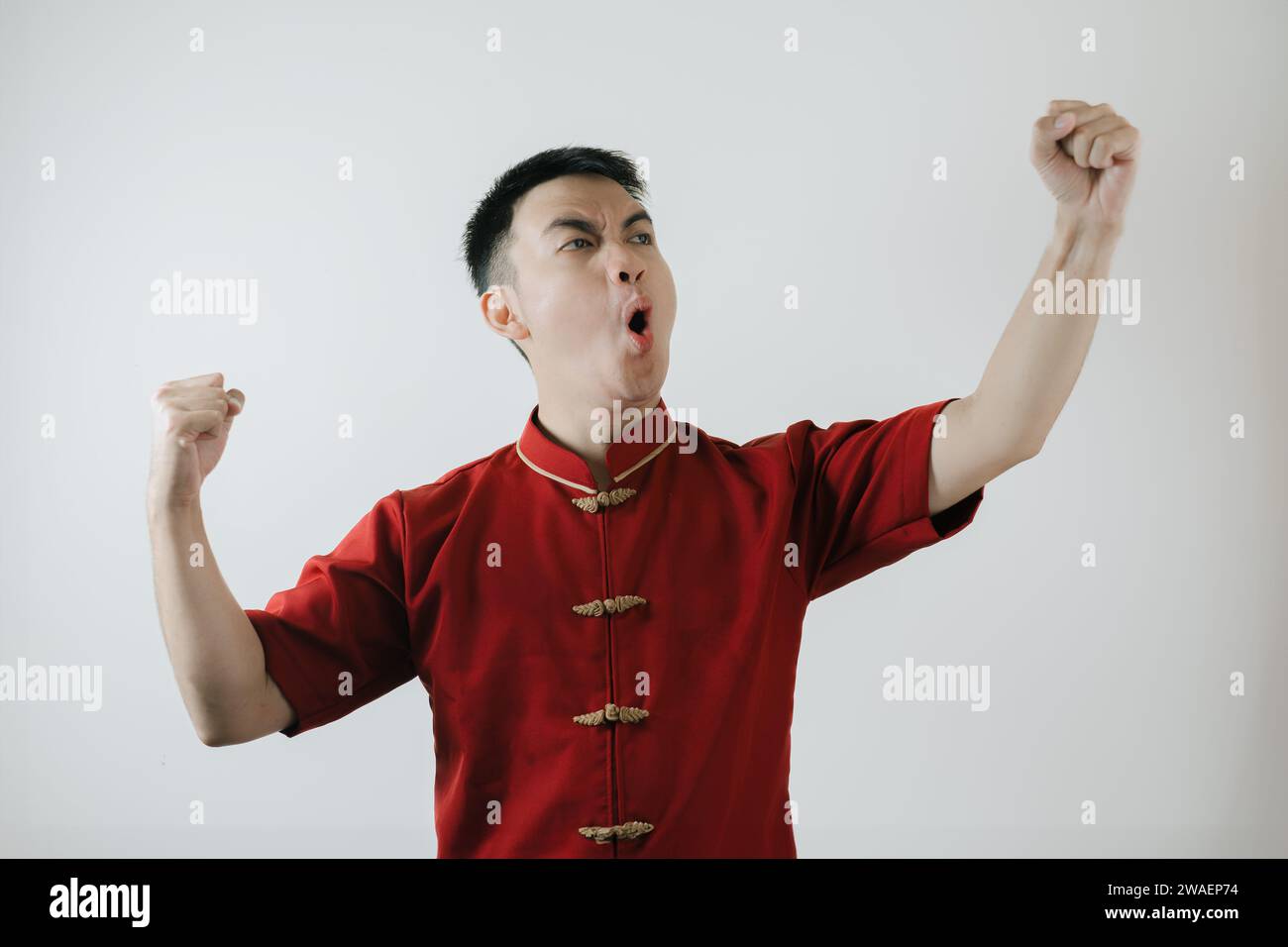 Happy and joyful expression of Asian man wearing Chinese traditional cloth called Cheongsam on Lunar New Year on white background Stock Photo