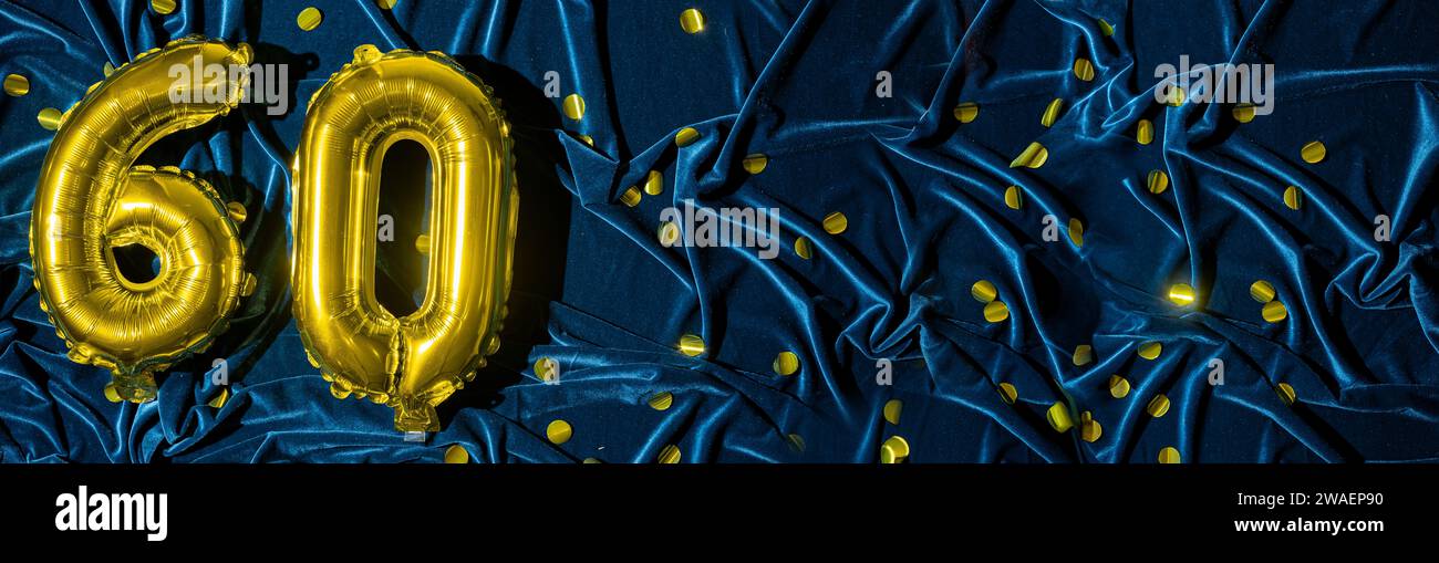 Gold foil balloon number number 60 on a background of blue velvet ...