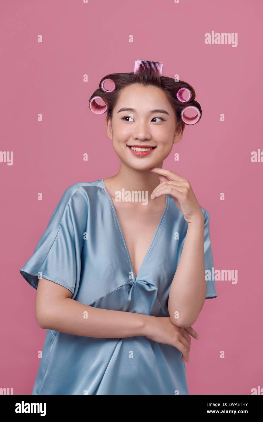 Portrait of young woman wearing hair rollers Stock Photo