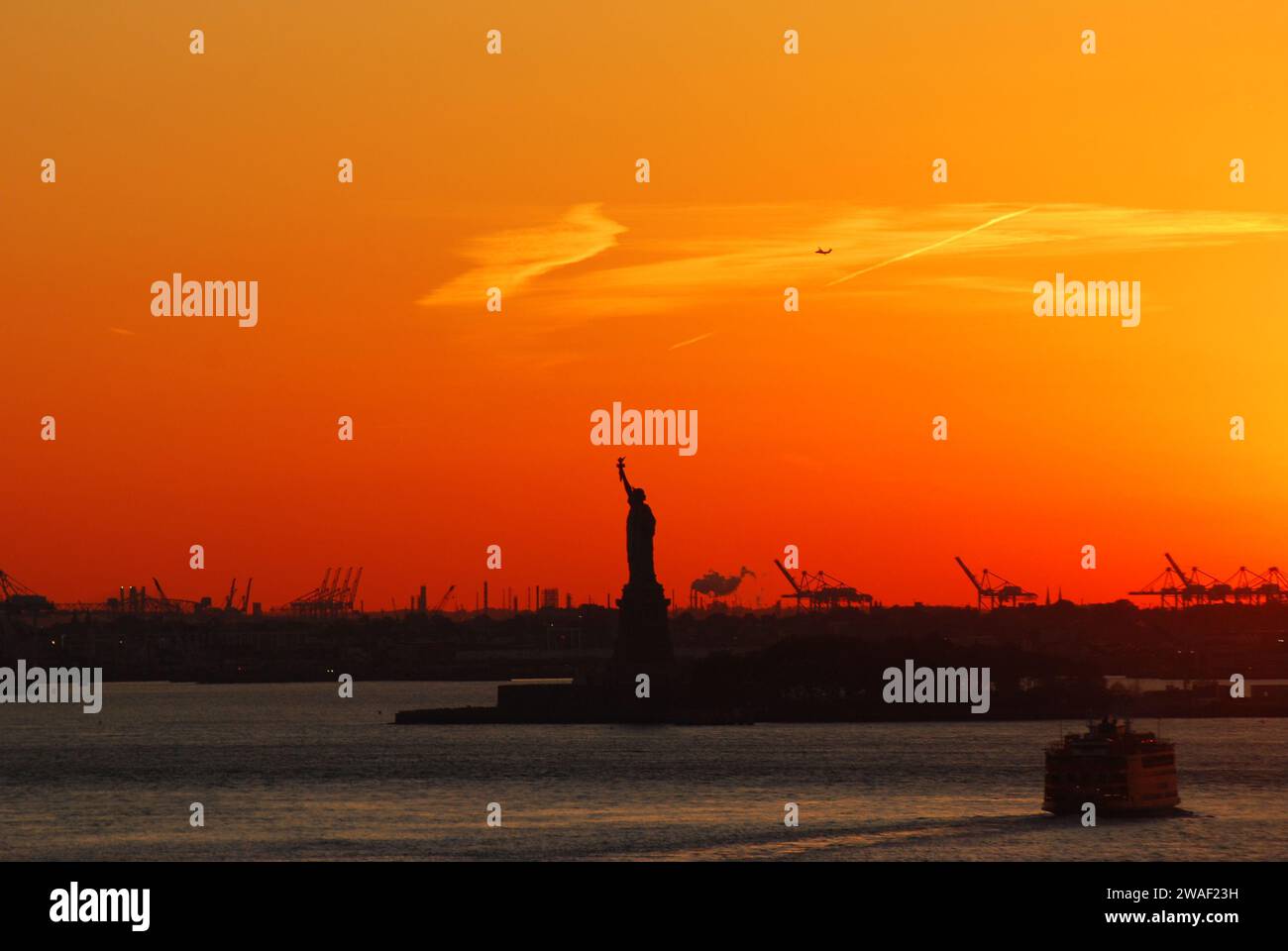 Silhouette of Statue of Liberty and Liberty Island in New York against ...