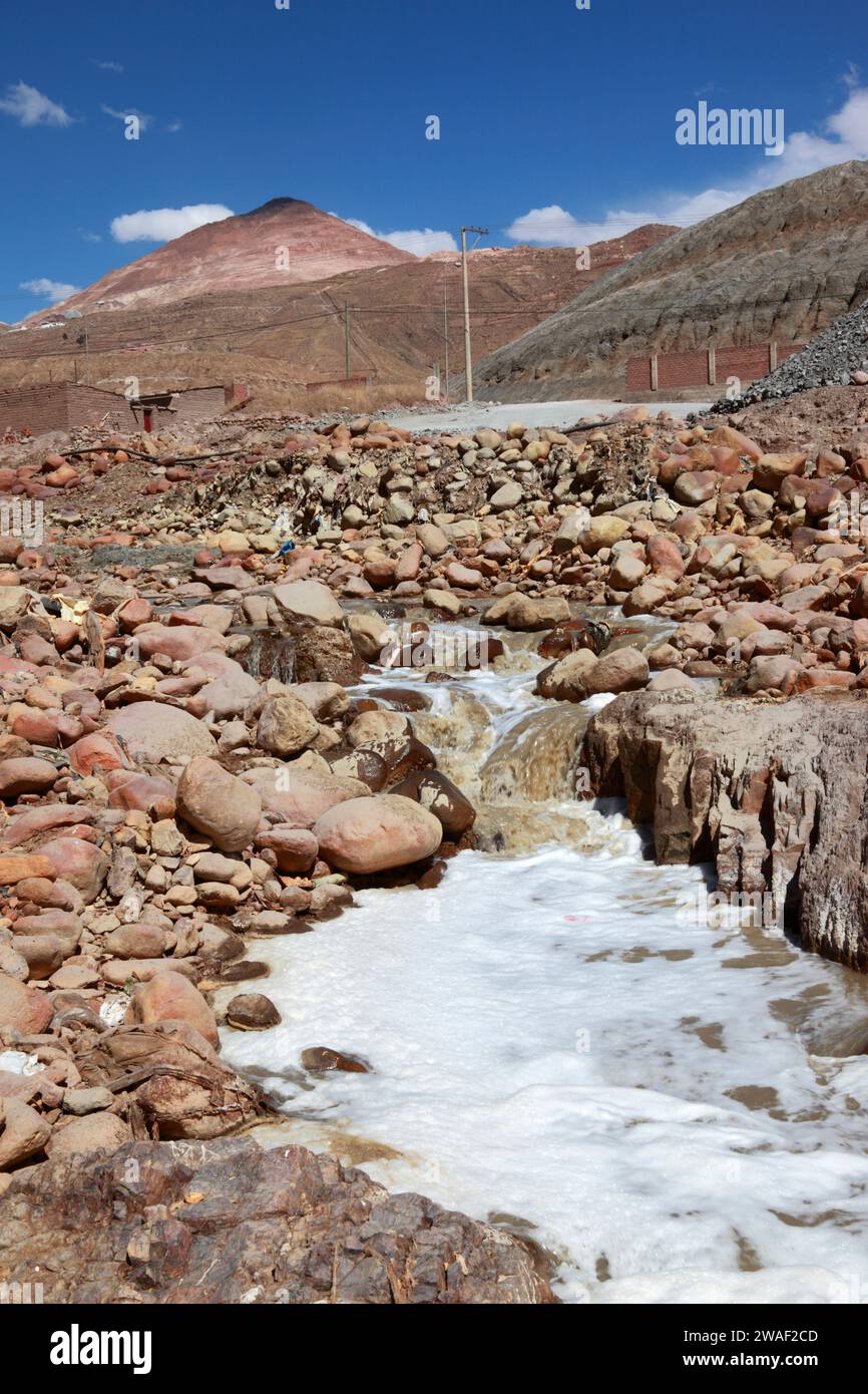 Stream polluted by mining activity and mineral processing, Cerro Rico in background, Potosi, Bolivia Stock Photo