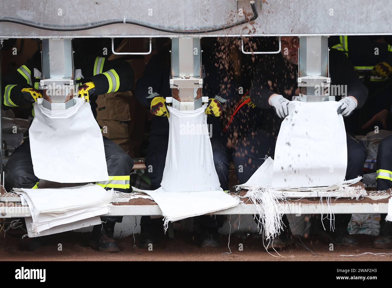 Sangerhausen, Germany. 04th Jan, 2024. Fire department helpers fill sandbags by machine. On the same day, Federal Chancellor Scholz and Saxony-Anhalt's Minister President Haseloff will visit the flood area around the Helme and talk to volunteers. Credit: Jan Woitas/dpa/Alamy Live News Stock Photo