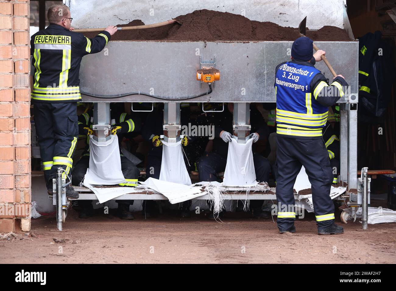Sangerhausen, Germany. 04th Jan, 2024. Fire department helpers fill sandbags by machine. On the same day, Federal Chancellor Scholz and Saxony-Anhalt's Minister President Haseloff will visit the flood area around the Helme and talk to volunteers. Credit: Jan Woitas/dpa/Alamy Live News Stock Photo