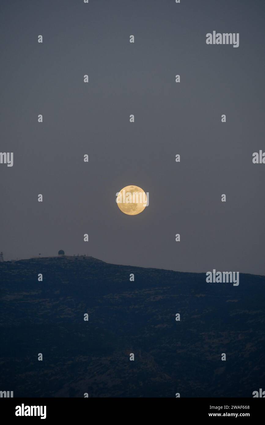 Fullmoon rising over mount Hymettos in Athens, Greece, moon, August moon, greek Stock Photo