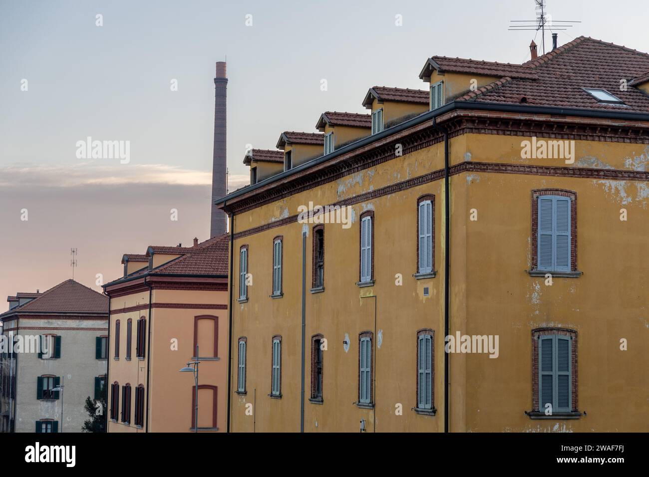 Crespi d'Adda, Italy - january 3 2024 -  workers village UNESCO site heritage Lombardy - in the picture: view of old buildings in hte village and chim Stock Photo
