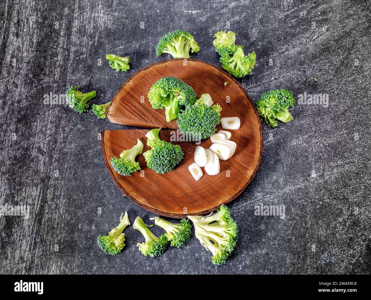Inflorescences of green broccoli and garlic - still life image. Wooden ...