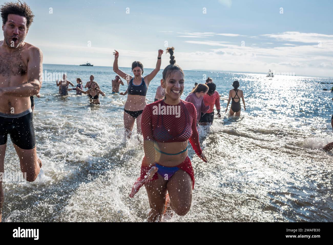 Brooklyn, New York - January 1, 2024: Group running out of the ocean, Coney Island Polar Bear New Years Day Plunge Stock Photo