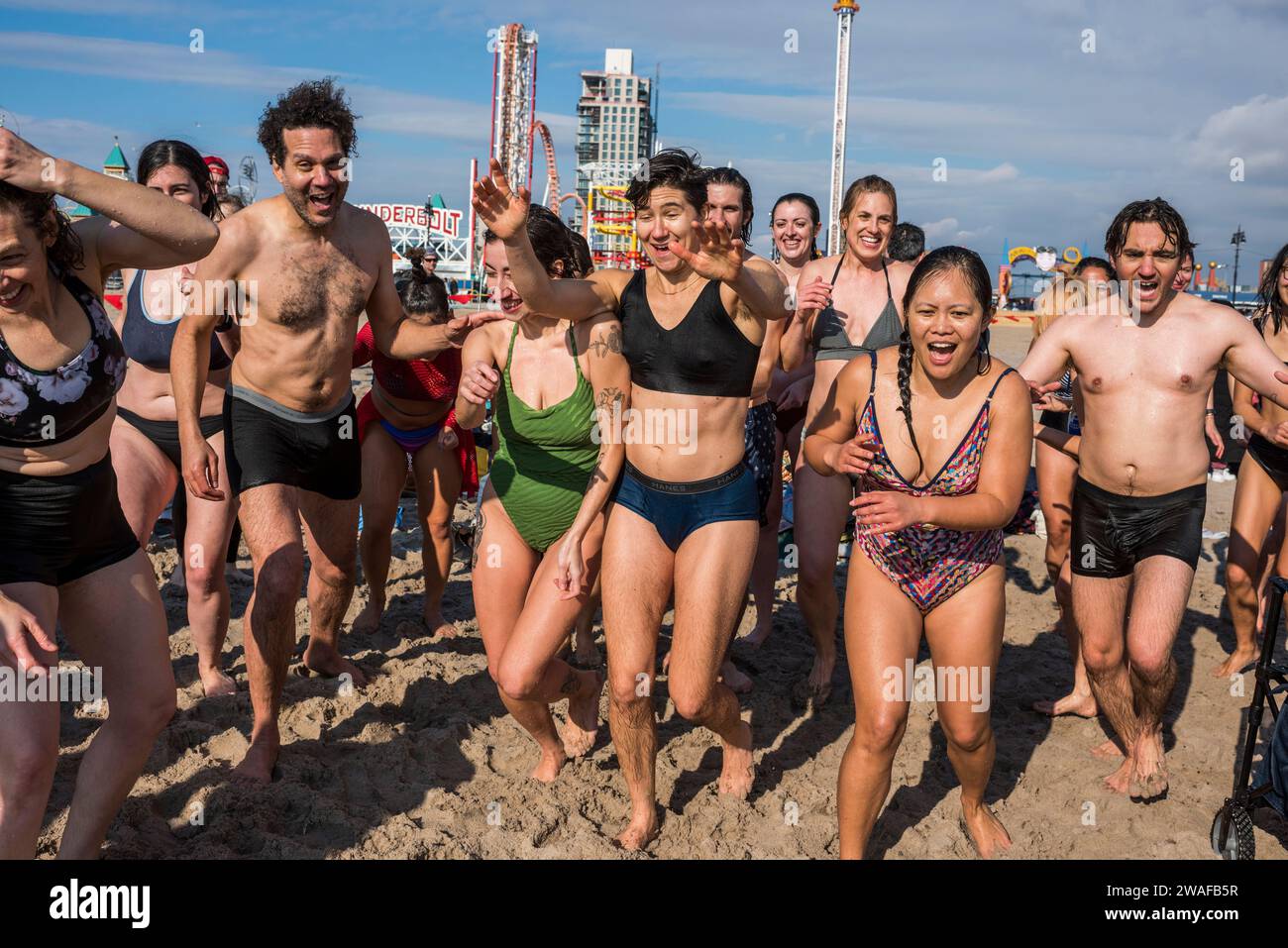 Brooklyn, New York - January 1, 2024: Group running into the ocean, Coney Island Polar Bear New Years Day Plunge Stock Photo