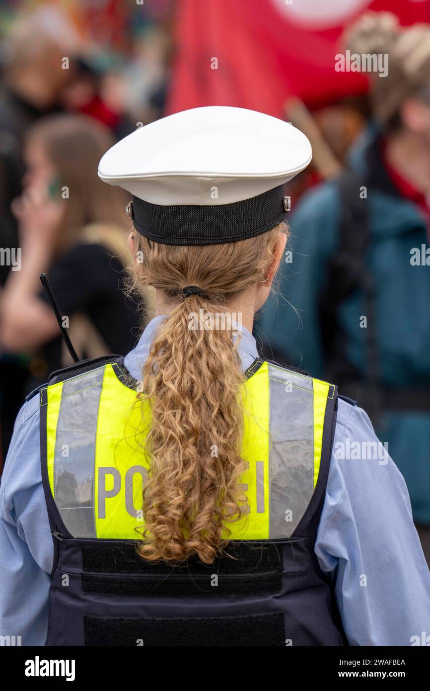 Polizistin mit Mütze, Weste und langen Haaren, zum Zopf gebunden, Polizistin *** Policewoman with cap, vest and long hair, tied into a plait, policewoman Stock Photo