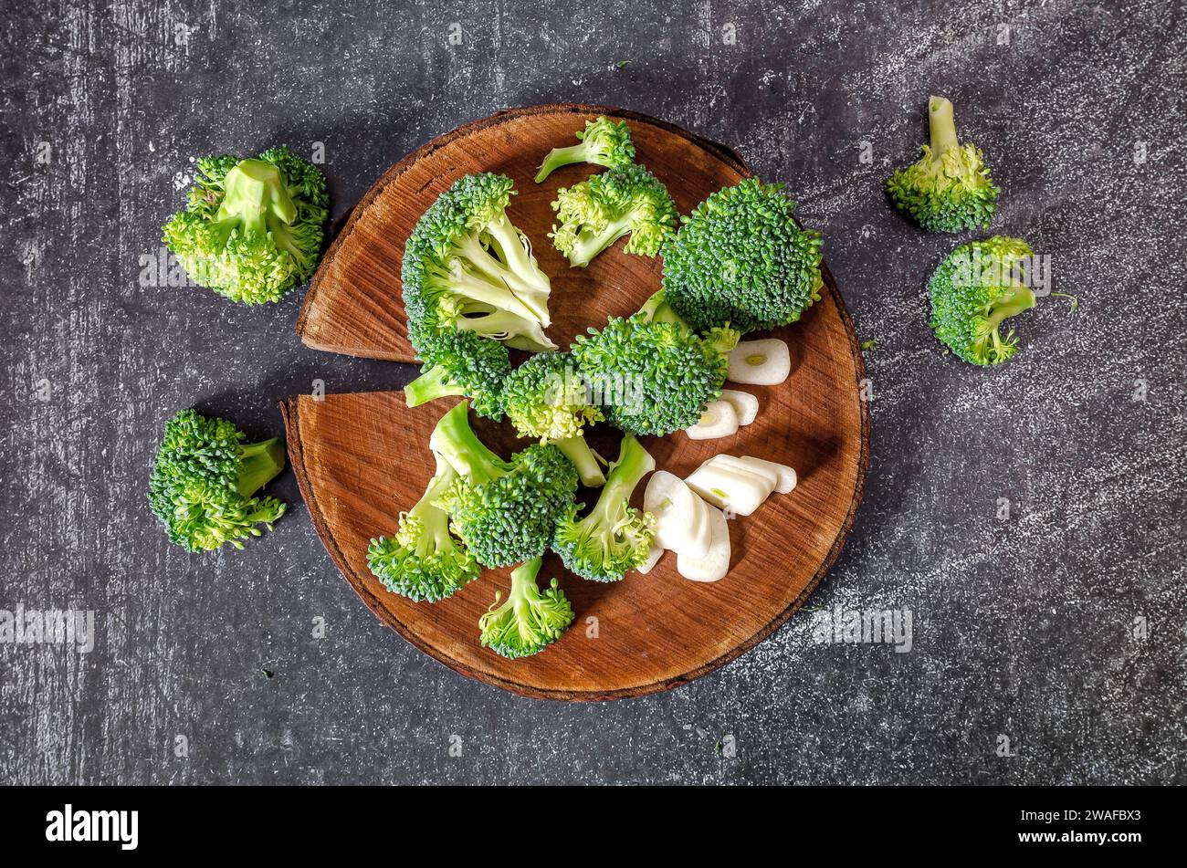 Inflorescences of green broccoli and garlic - still life image. Wooden ...