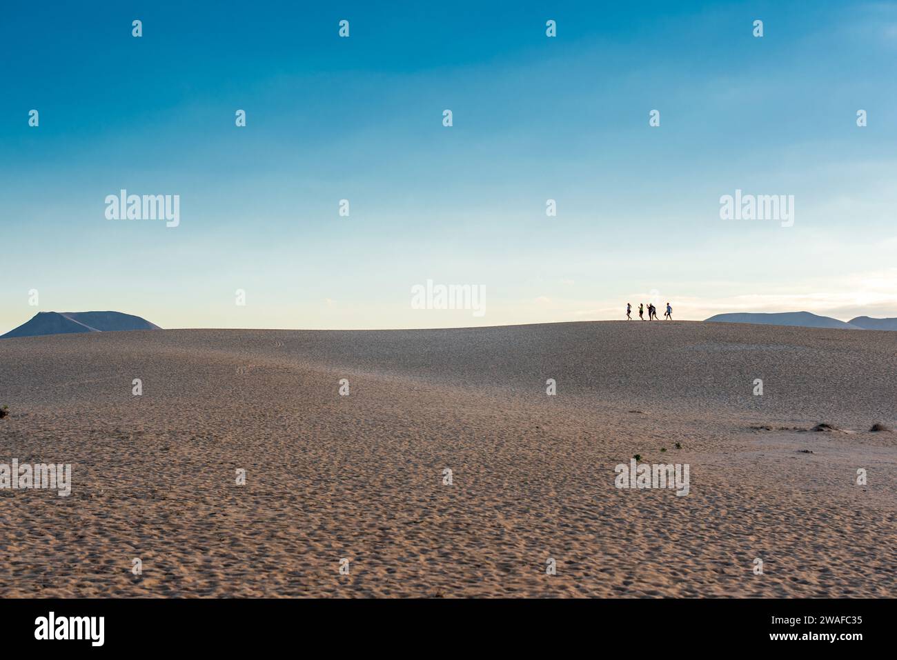 Silhouettes of people on sand dunes on Fuerteventura Stock Photo