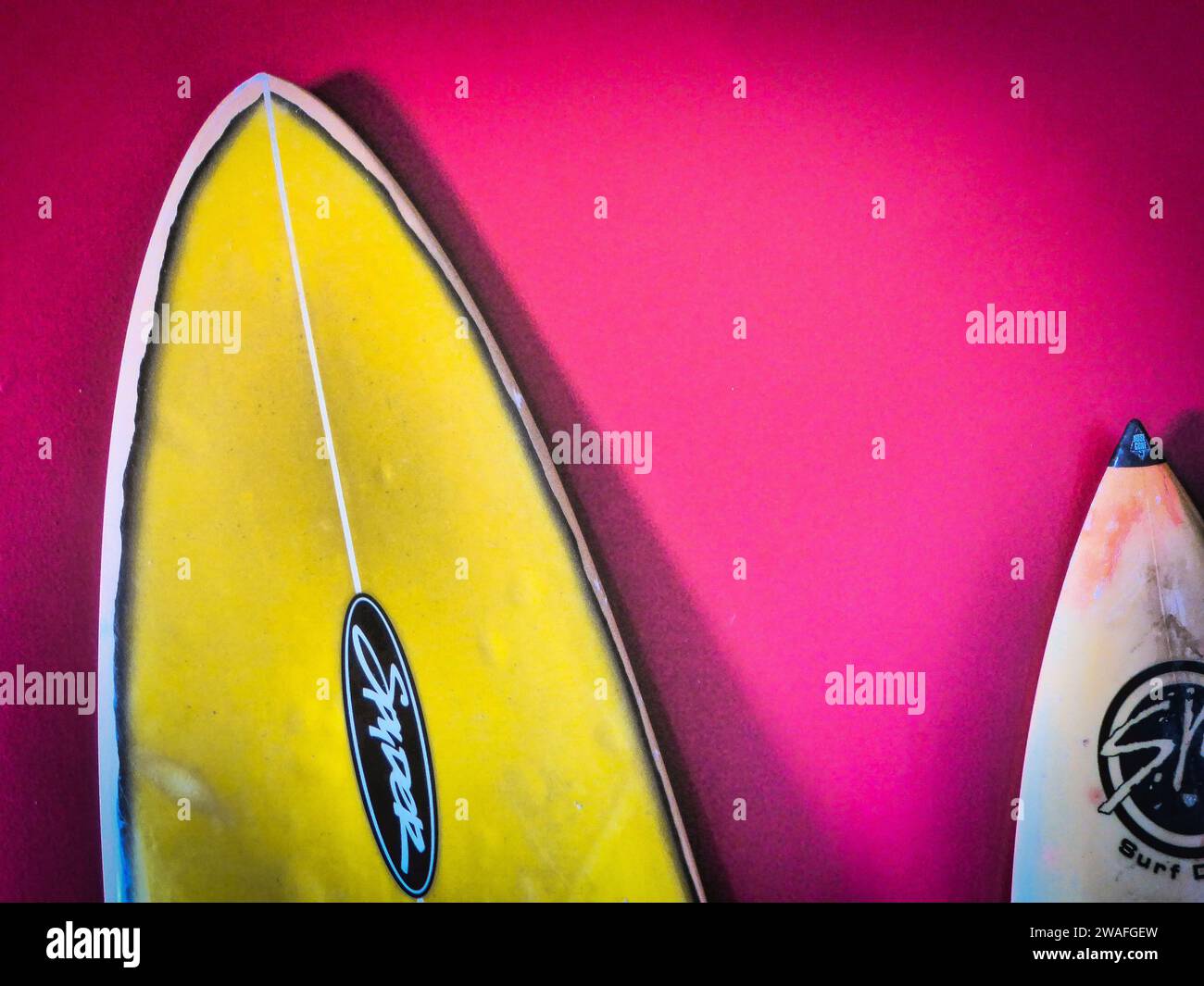 A colorful photo of two surfboards leaning against a wall Stock Photo