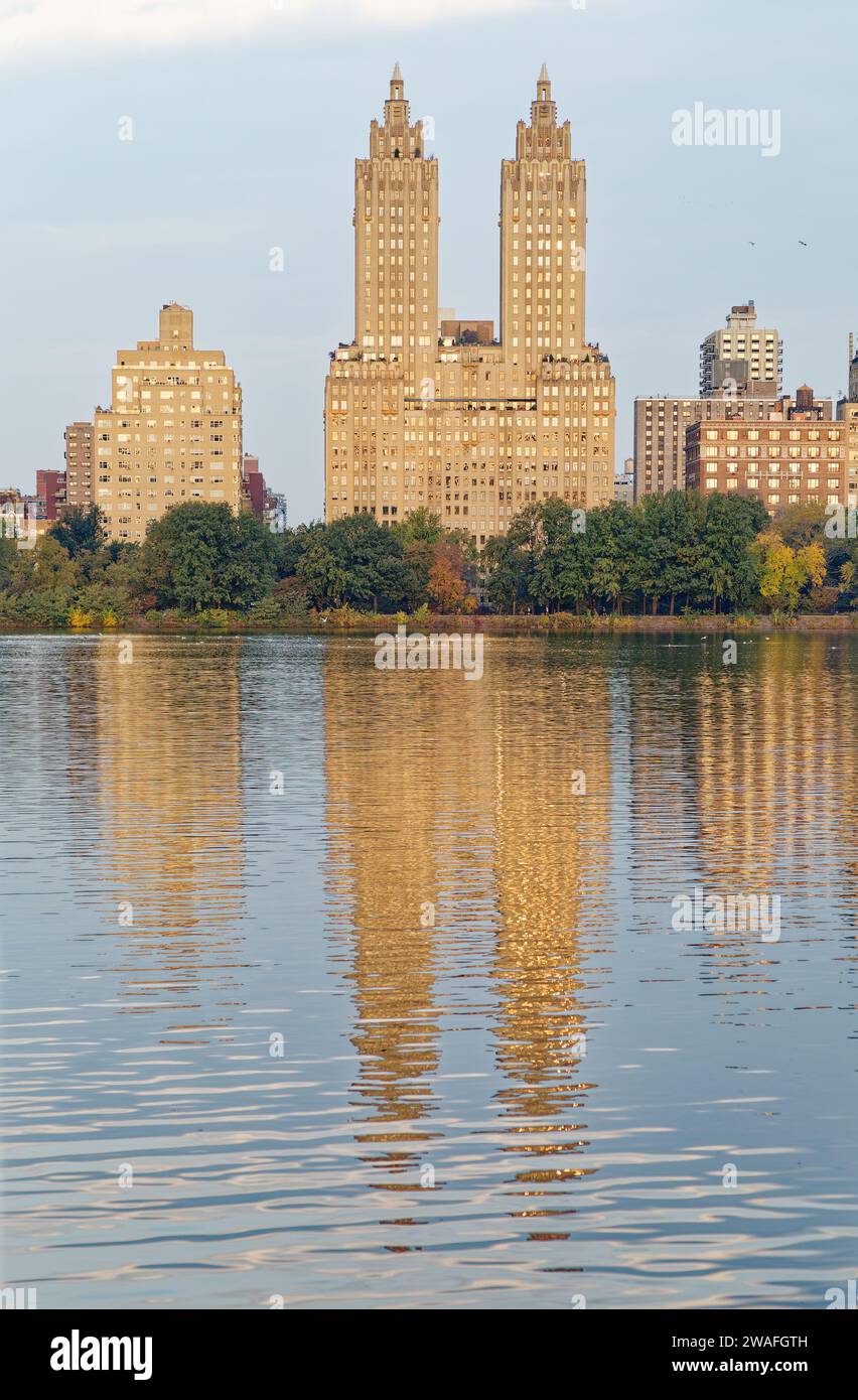 The landmark Eldorado towers dominate the early morning skyline reflected in Jacqueline Kennedy Onassis Reservoir in NYC’s Central Park. Stock Photo