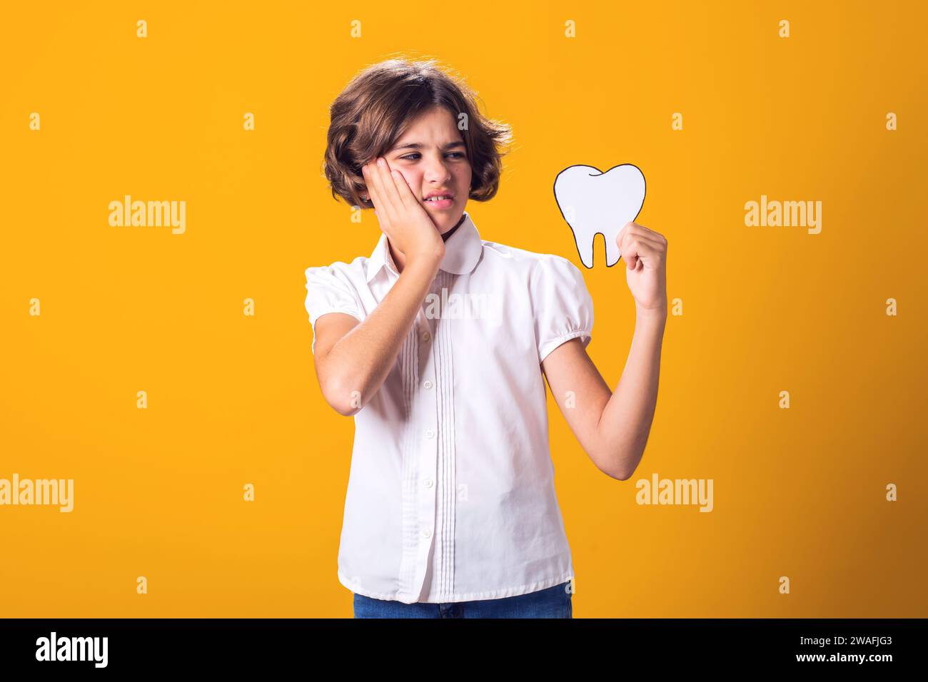 Child girl holding papercraft tooth and feel toothache. Dental health ...