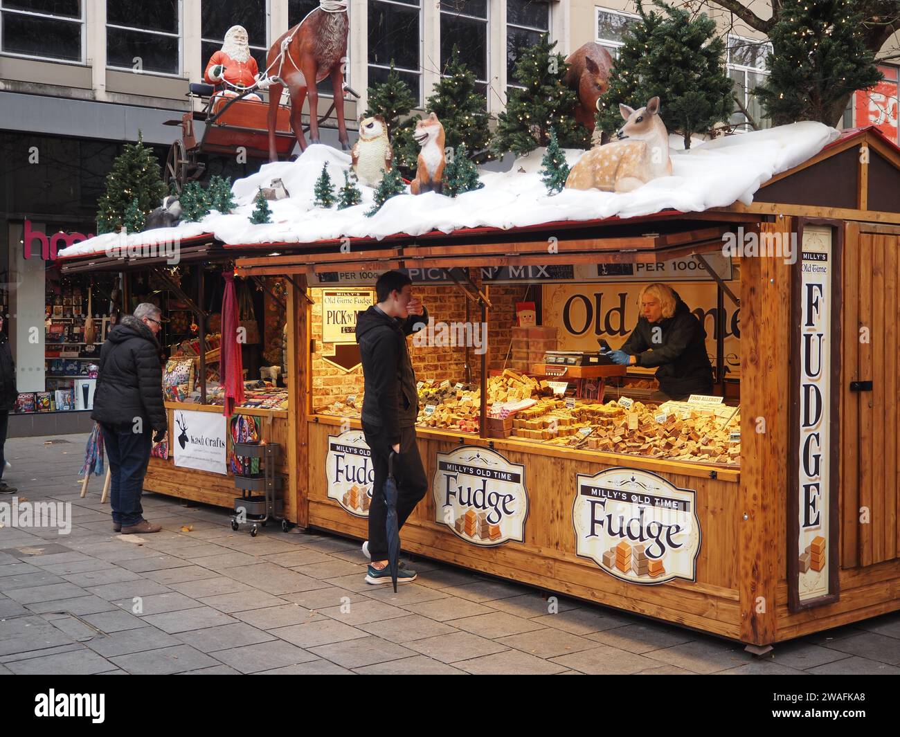 Fudge stall with roof decorated with Santa, snowmen and imitation snow at Bristol Christmas market, Broadmead, Bristol. Stock Photo