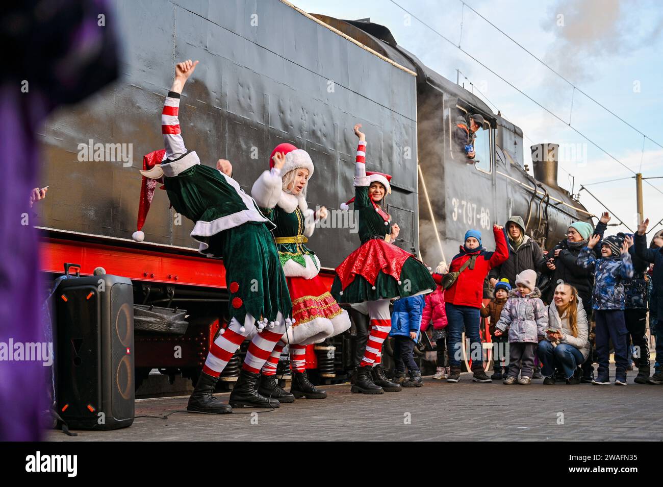 Non Exclusive: LVIV, UKRAINE - DECEMBER 31, 2023 - Entertainers perform on the platform at the Christmas Express, a retro train with a steam locomotiv Stock Photo