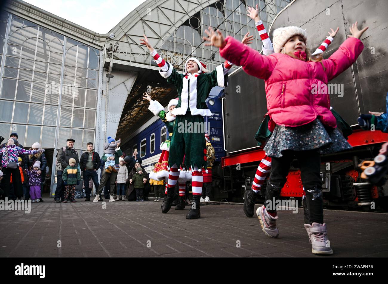 Non Exclusive: LVIV, UKRAINE - DECEMBER 31, 2023 - Entertainers perform on the platform at the Christmas Express, a retro train with a steam locomotiv Stock Photo