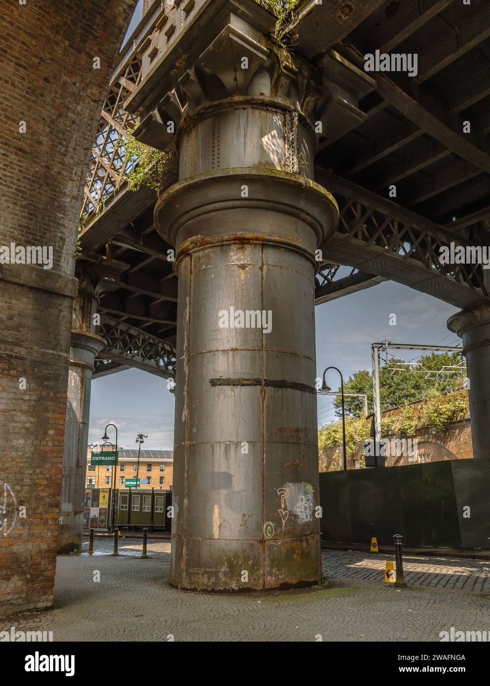 Detail of a steel rail bridge supported by a large metal pillar. Concept of strength, connectivity, support or travel. Stock Photo