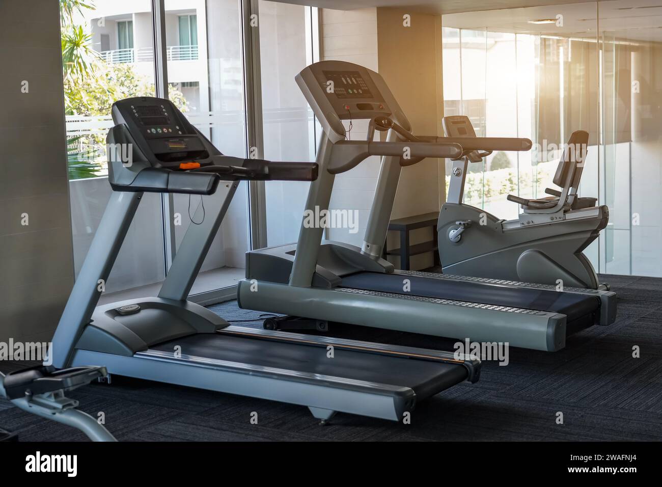 Modern gym interior with equipment. Fitness club with training exercise bikes in outside backlight Stock Photo