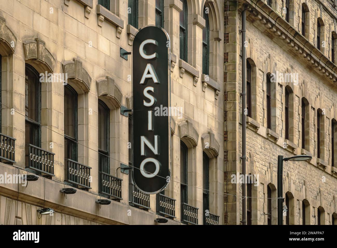 A casino sign mounted to the side of a building. Gambling, gambling addiction, leisure or risk concept. Stock Photo
