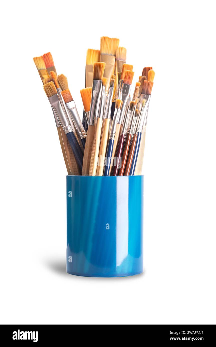 Paintbrushes in a blue plastic cup. Numerous used flat and round paintbrushes of various sizes, used by artists in one stroke painting. Stock Photo