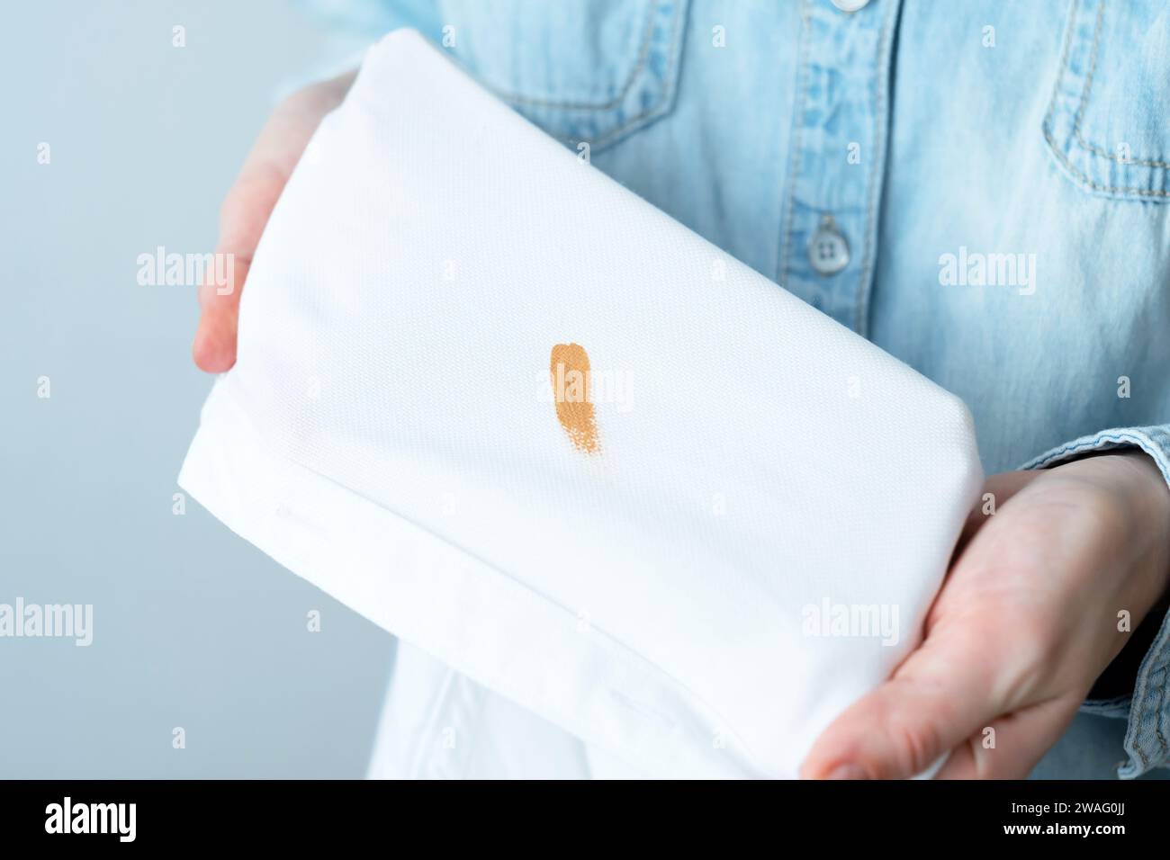 Cosmetic stains on the white clothes. The housewife evaluates the stain