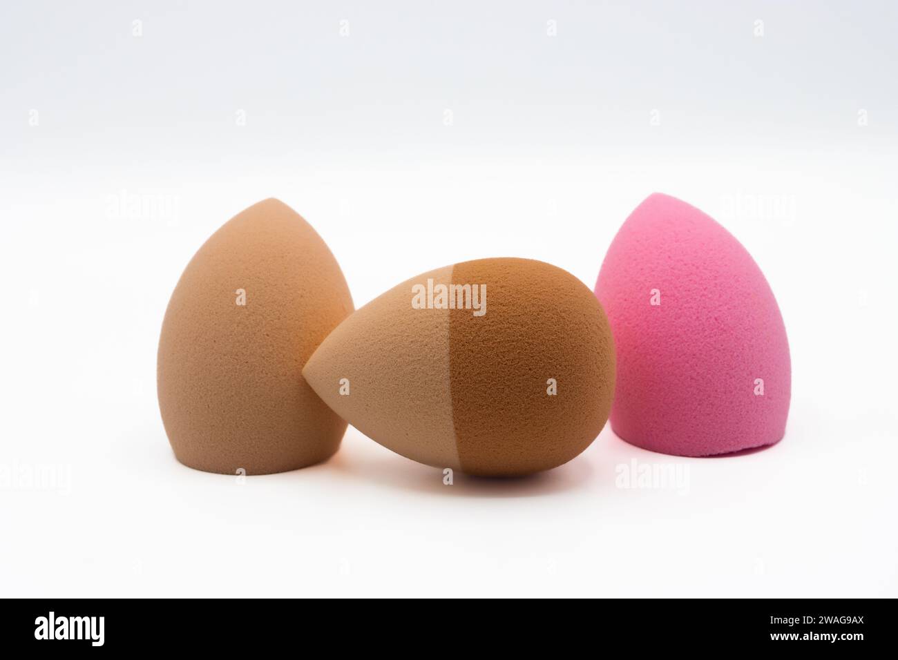 Multicolored beauty blenders. Three sponges for applying makeup on white background Stock Photo