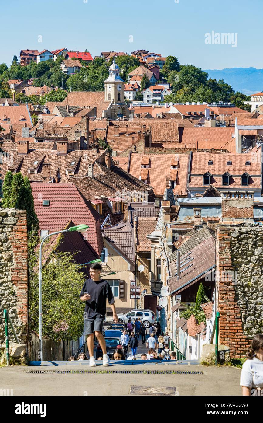 Tourists on the streets in the old town of Brasov. Medieval old houses with red tile roofs Stock Photo