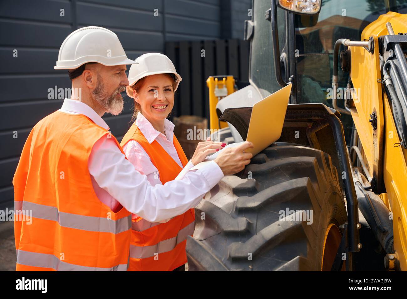 Construction professionals checking data on laptop during building inspection Stock Photo