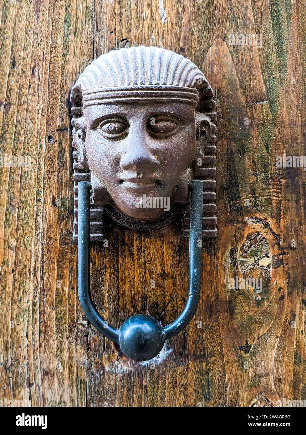 Vintage style doorknocker of an Egyptian head, a door in Italy Stock Photo