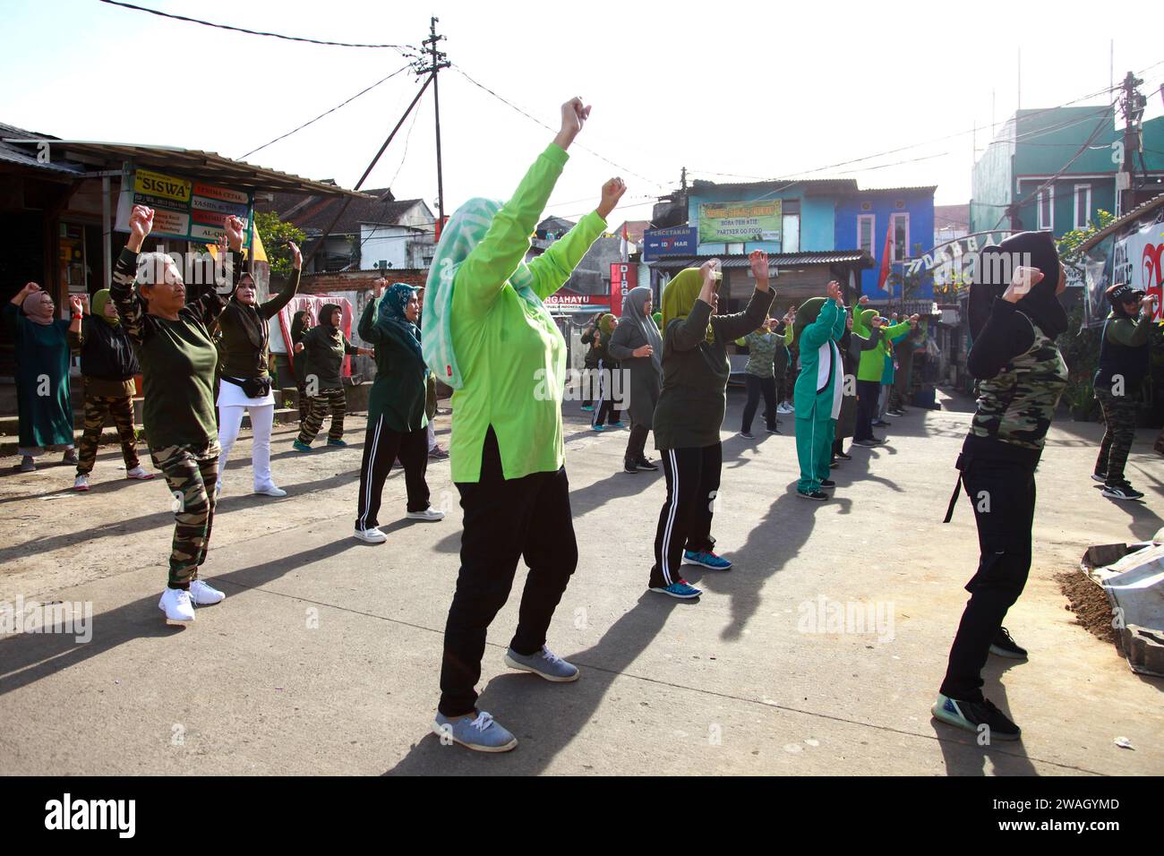 Muslim Women doing early morning Aerobics. The women are mostly middle-aged and wearing military fatigues. Stock Photo