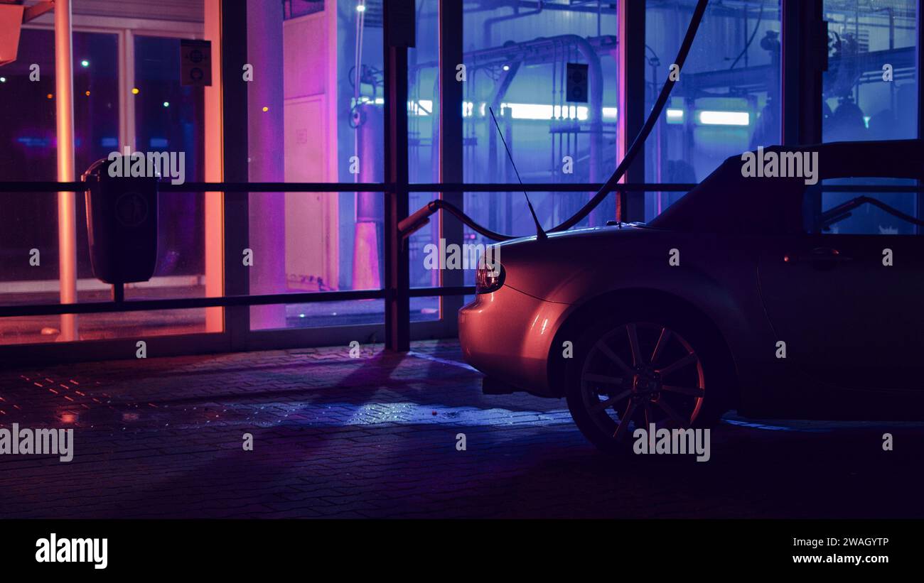 Silver JDM convertible at night in front of a car wash and neon lights Stock Photo