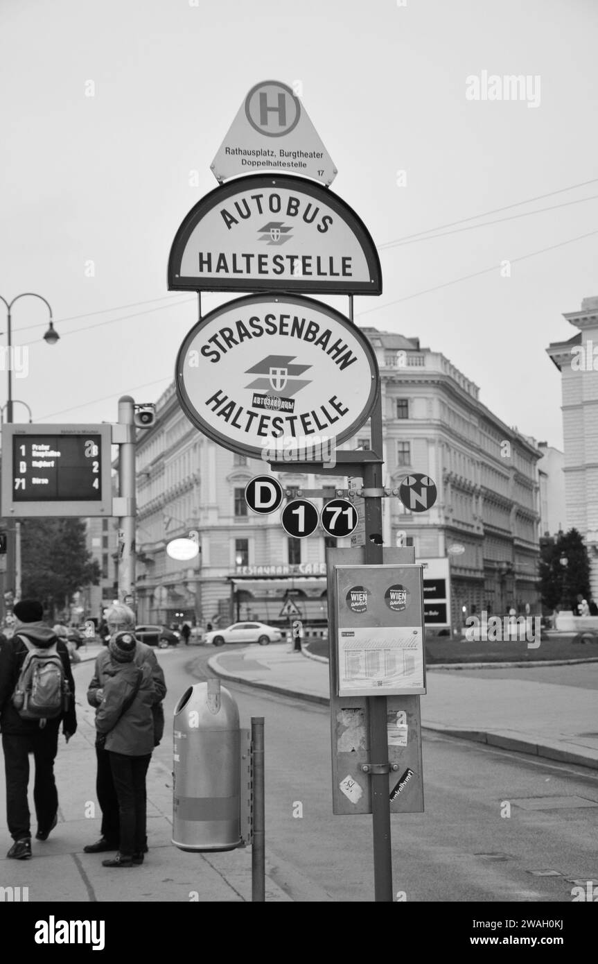 A vertical greyscale shot of an old tram sign at a bus stop in Vienna, Austria Stock Photo