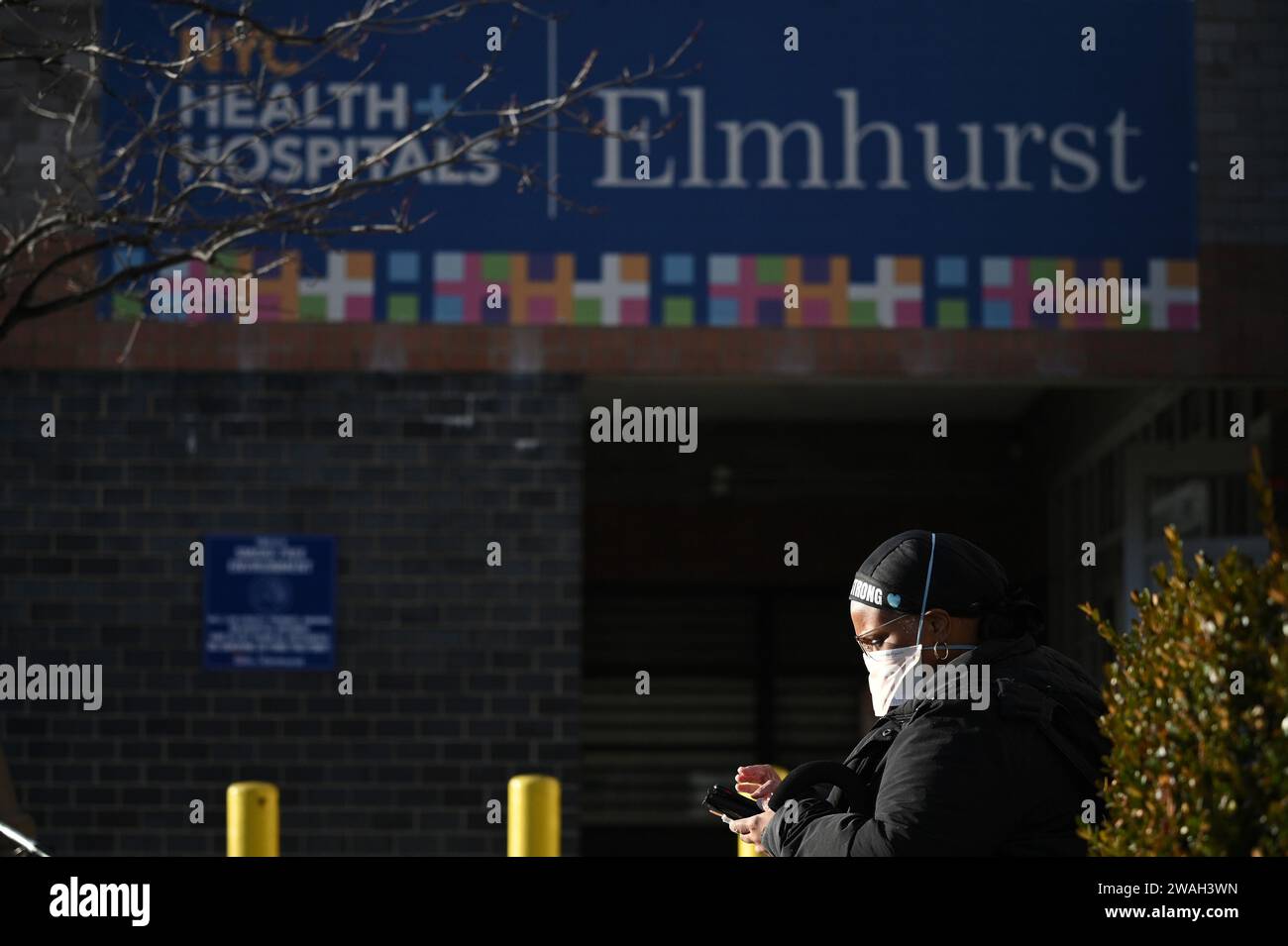 New York, USA. 04th Jan, 2024. Wearing a mask, a nurse sits outside