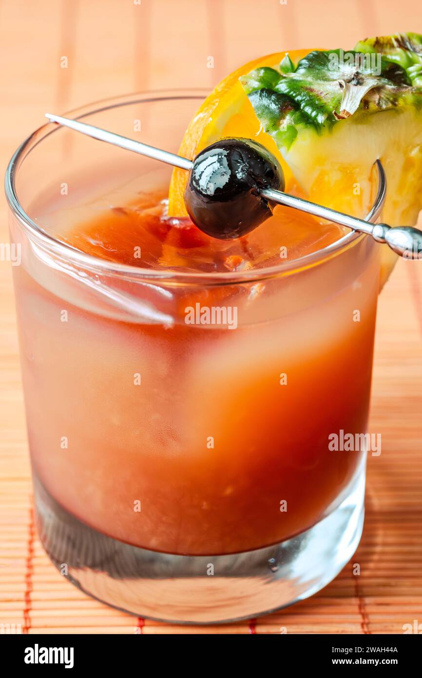 Bermuda Rum Swizzle cocktail garnished with fruits Stock Photo