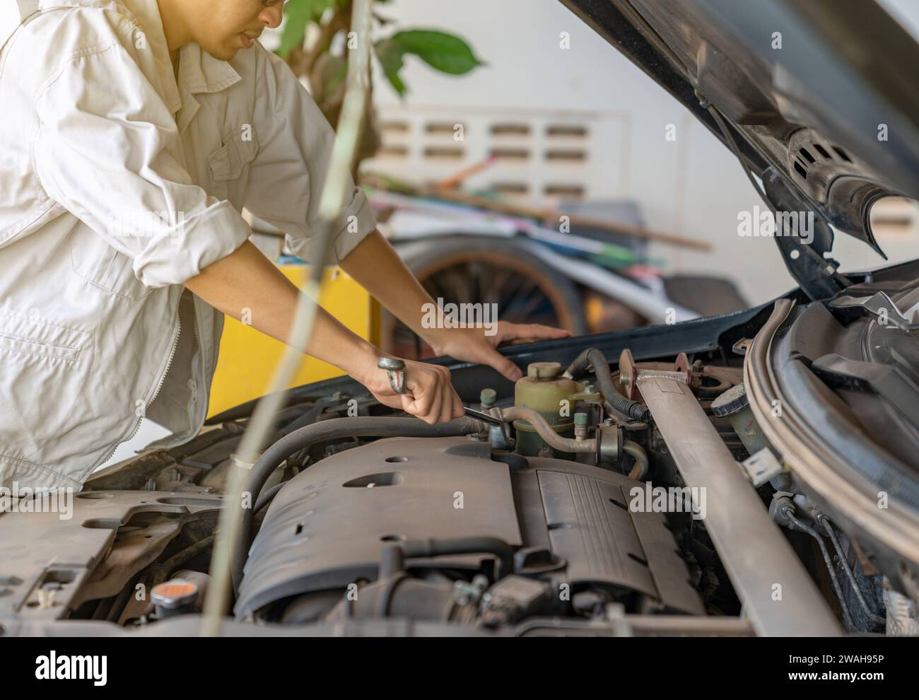 Car service tightening nuts of engine cover at the maintenance garage. Auto service, close up