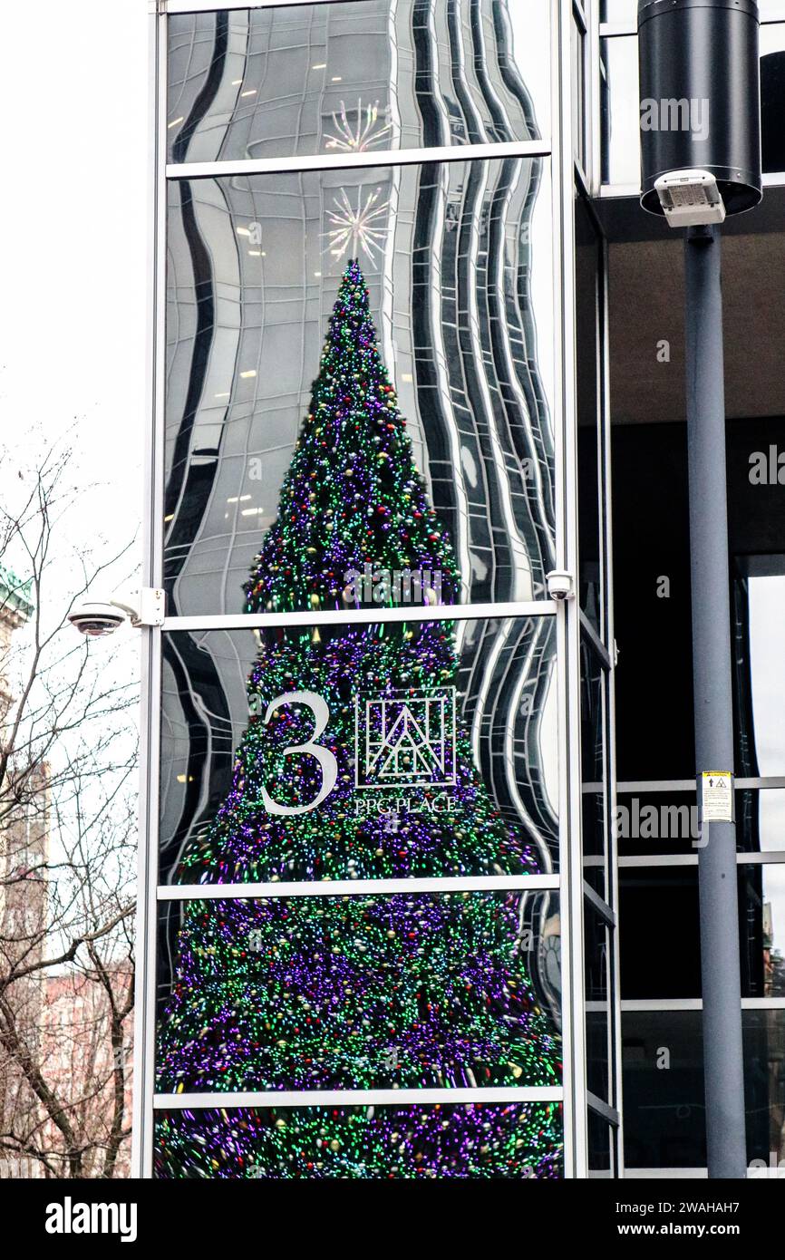 The number three 3 stand out against the reflection of the holiday tree at the PPG arena ice skating rink Stock Photo