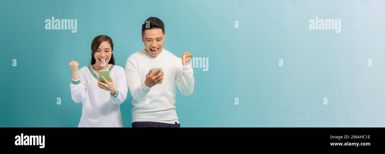 Excited people man and woman looking at each other while both using ...