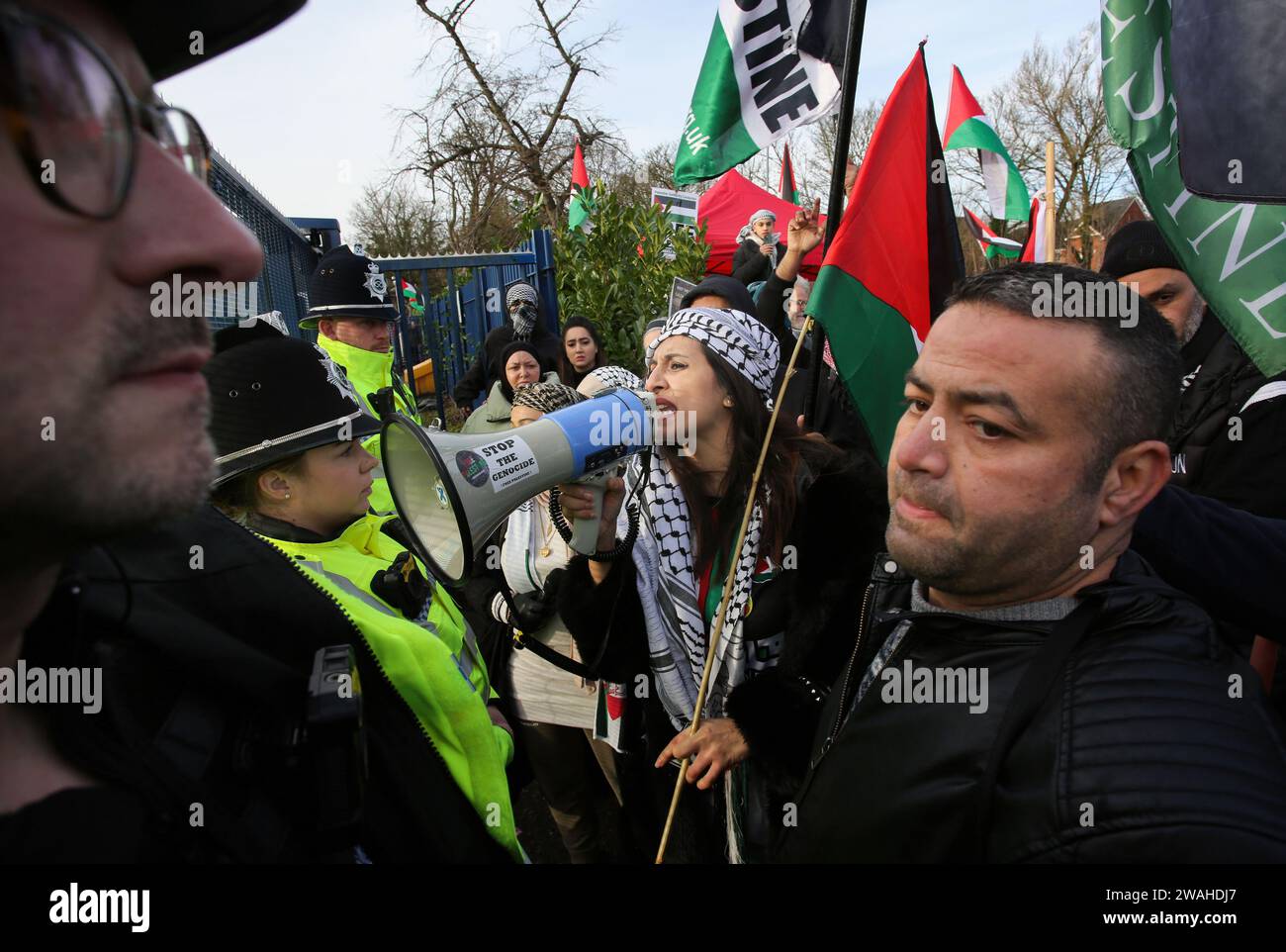 Shenstone, UK. 04th Jan, 2024. Police officers stop protesters outside the drone factory during the demonstration. Protesters gathered outside UAV Engines and demanded it's closure. The company owned by Israeli Defence company Elbit Systems provide engines and other parts for drones that protesters say are currently being used to watch and fire missiles by the Israelis against Palestinian civilians in their war in Gaza. Credit: SOPA Images Limited/Alamy Live News Stock Photo