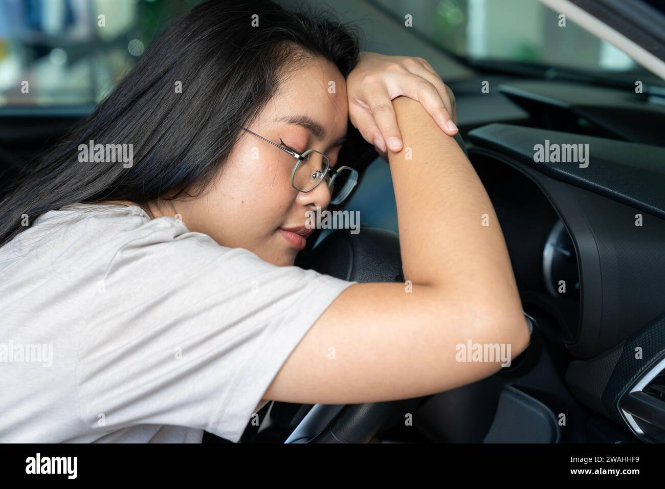 Young woman Asian are feeling sleepy while driving Stock Photo
