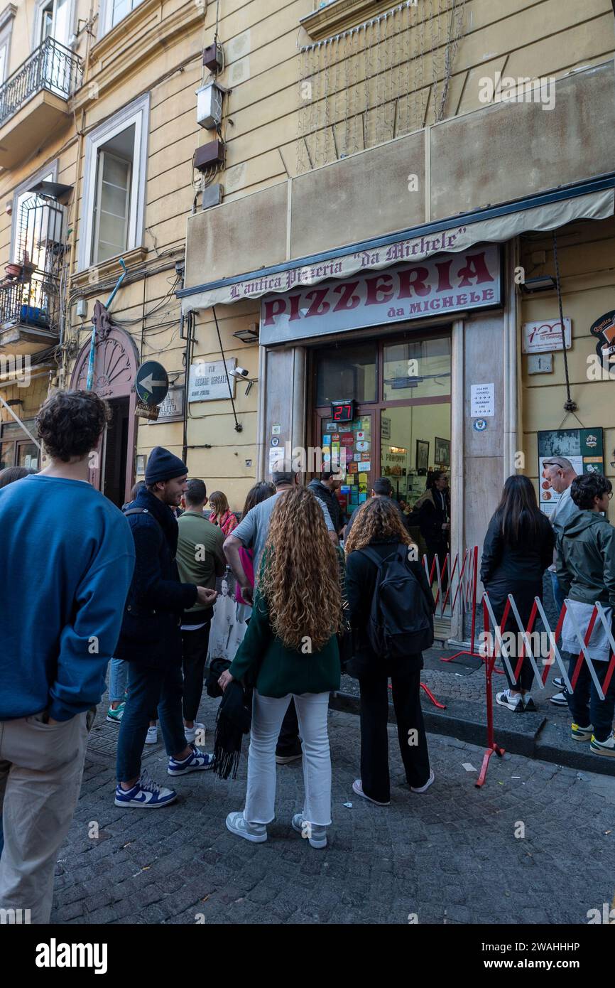 Napoli, Italy: 2023 November 18: People waiting on the street at La Antica Pizzeria Da Michele from 1870 where the authentic Margherita pizza is made Stock Photo
