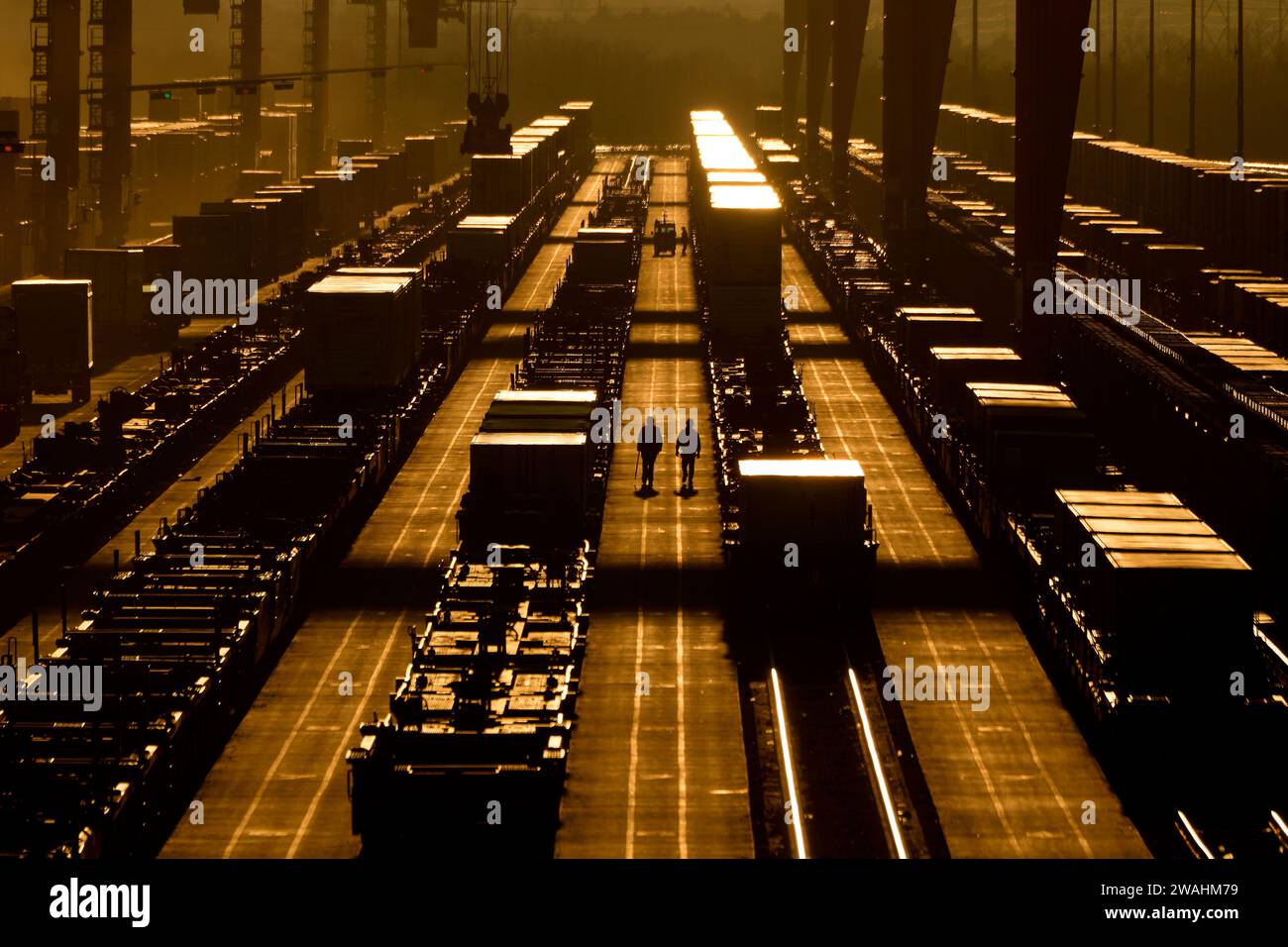 Workers walk among shipping containers at a BNSF intermodal terminal