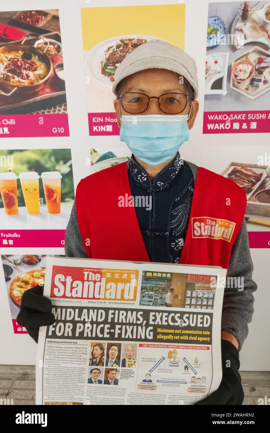 China, Hong Kong, Hong Kong Island, Elderly Lady distributing English Newspaper Stock Photo