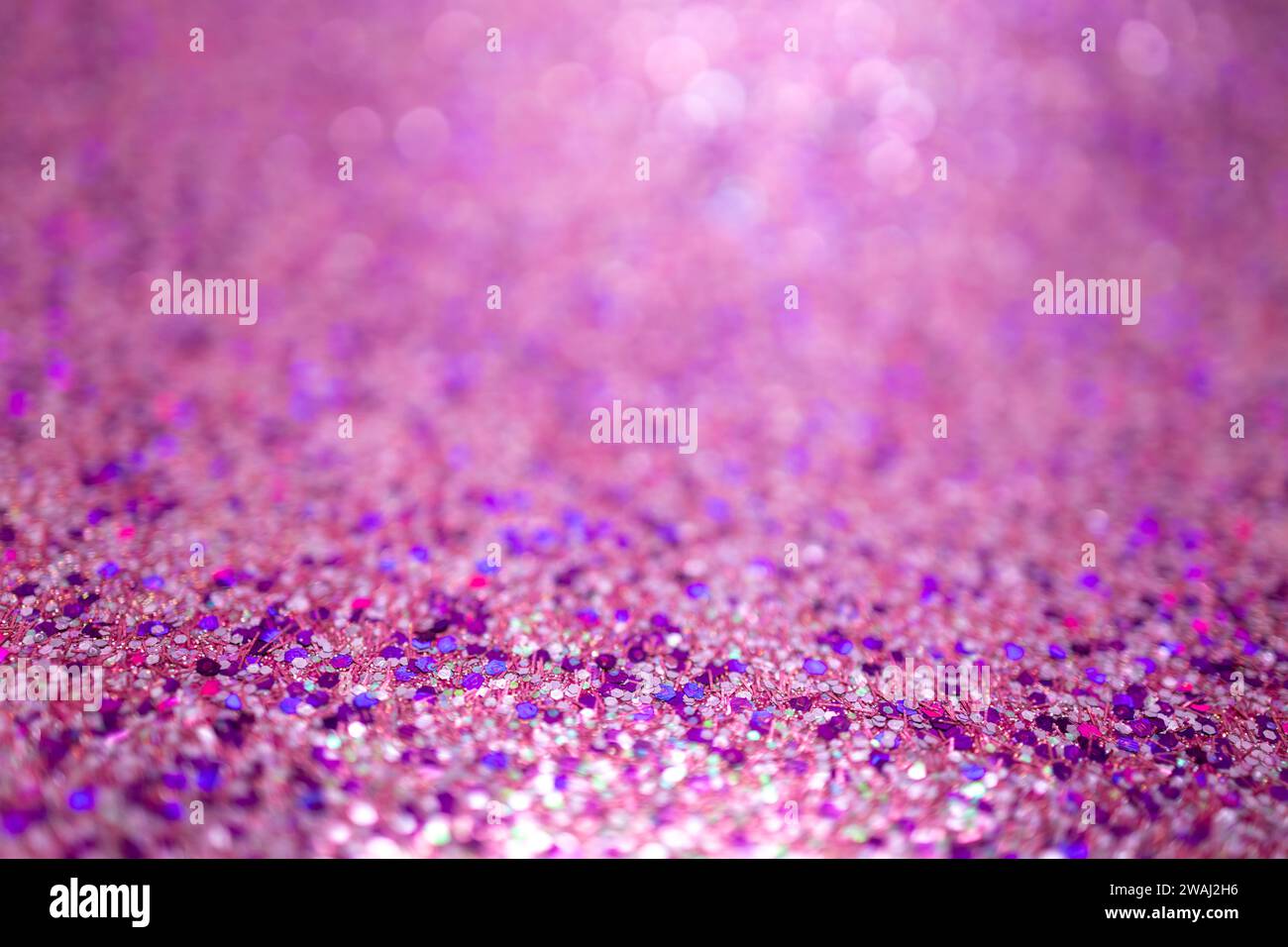 Defocused shimmering pink glitter texture background with vibrant color and bokeh Stock Photo