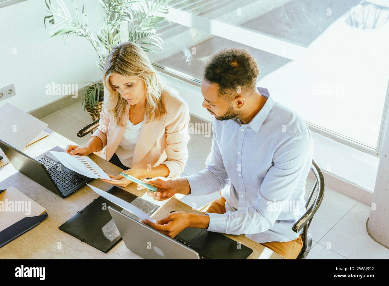 Two coworkers analyzing data while working together in the office. Business concept. Stock Photo