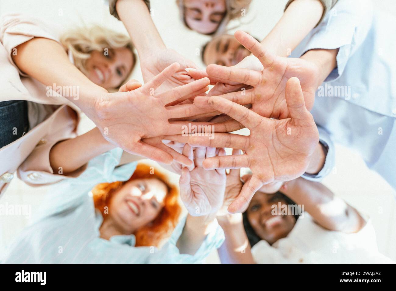 Diverse business people putting their hands together showing unity and support. Business and teamwork concept. Stock Photo