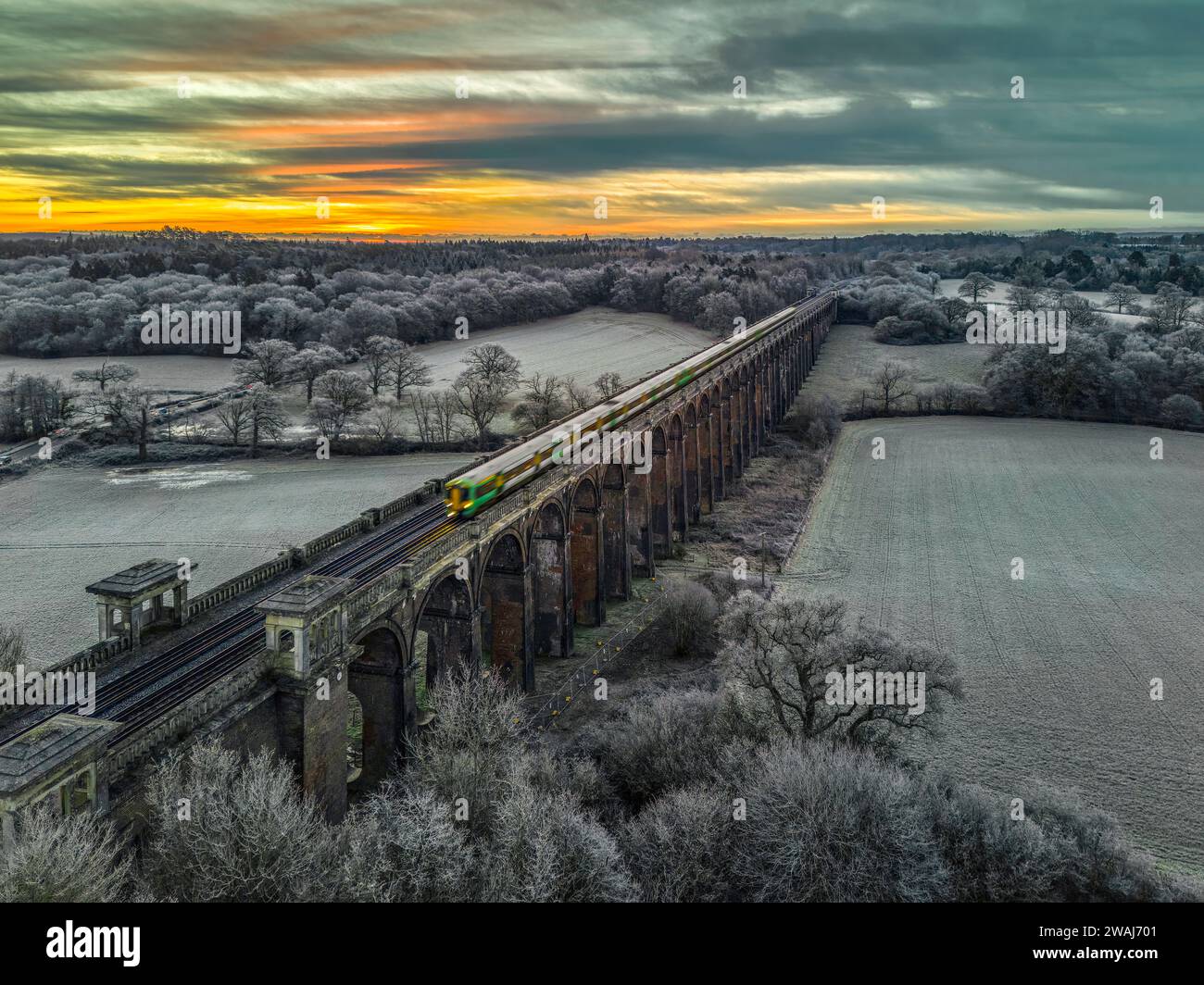 Balcombe viaduct or Ouse valley viaduct in Sussex carrying the London to Brighton railway line with a Southern train crossing on a frosty morning Stock Photo