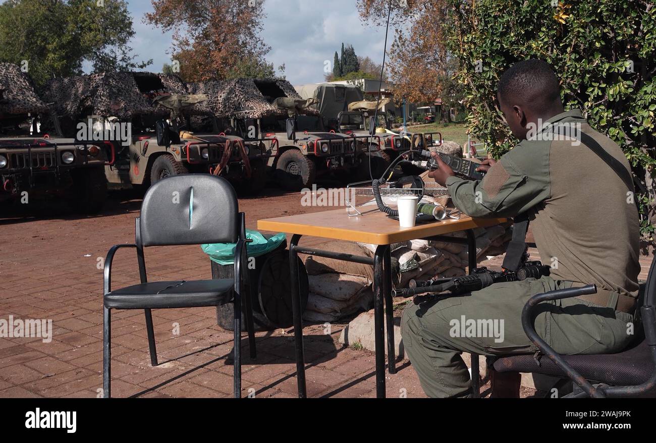 An Israeli soldier sits guard in Kibbutz Dafna which is situated near the border with Lebanon and was evacuated from its residents since the cross-border fire began after the October 7 attacks by Palestinian militants from the Gaza Strip on January 4, 2024 in Kibbutz Dafna, Israel. Stock Photo