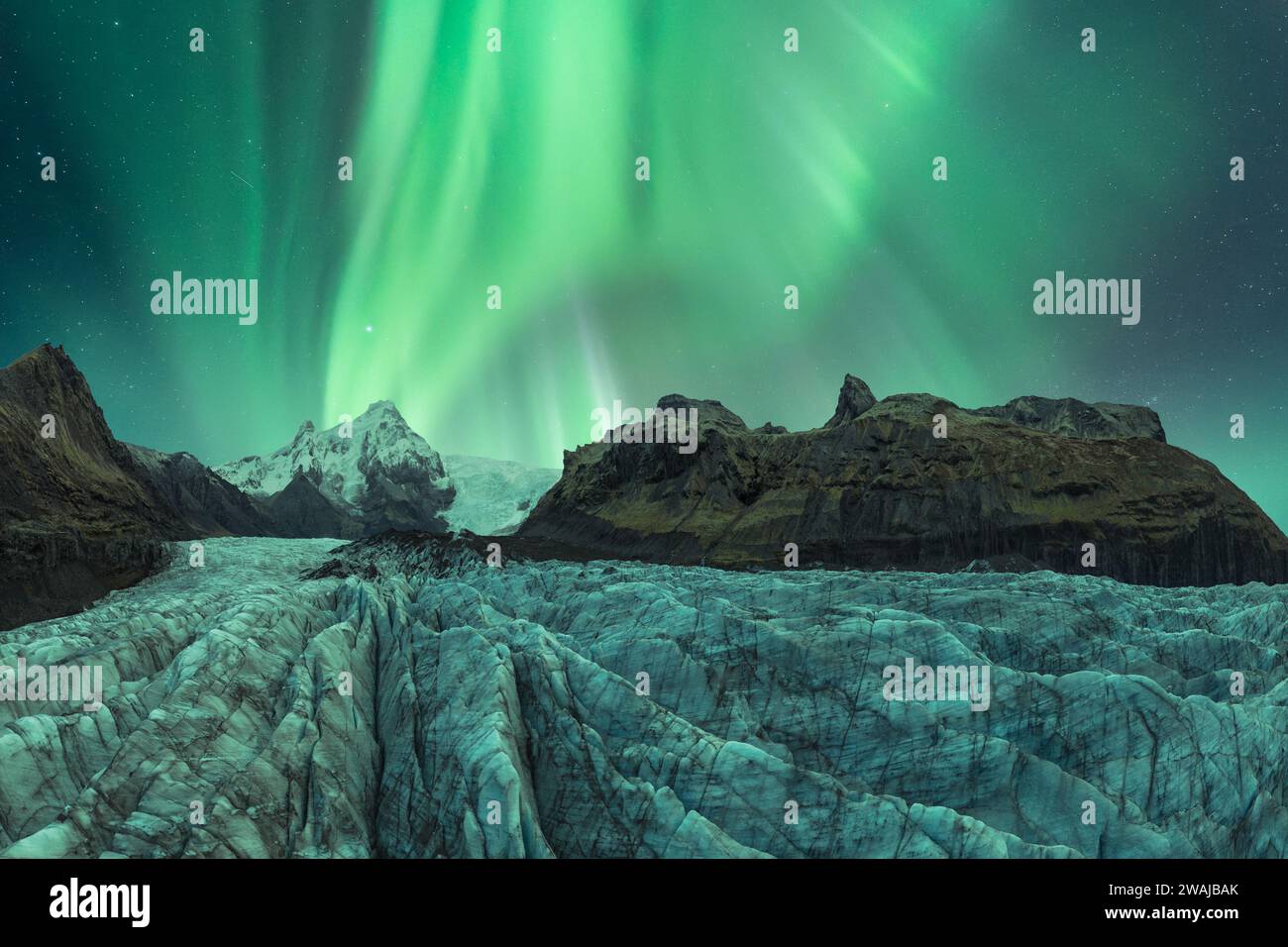 The enchanting Aurora Borealis illuminates the night sky above a stark ...